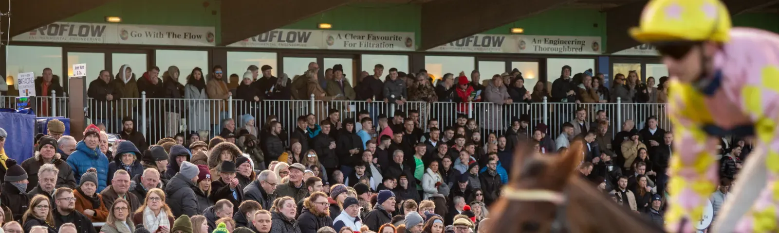 The crowds at Sedgfield with a horse and jockey starting to pass by