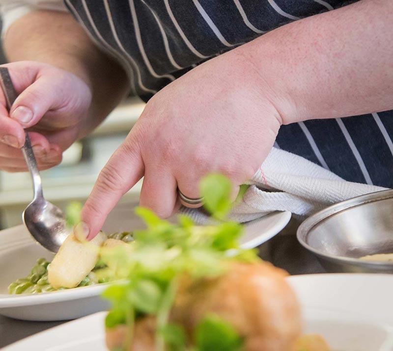 A chef lovingly prepares food for the days guests.