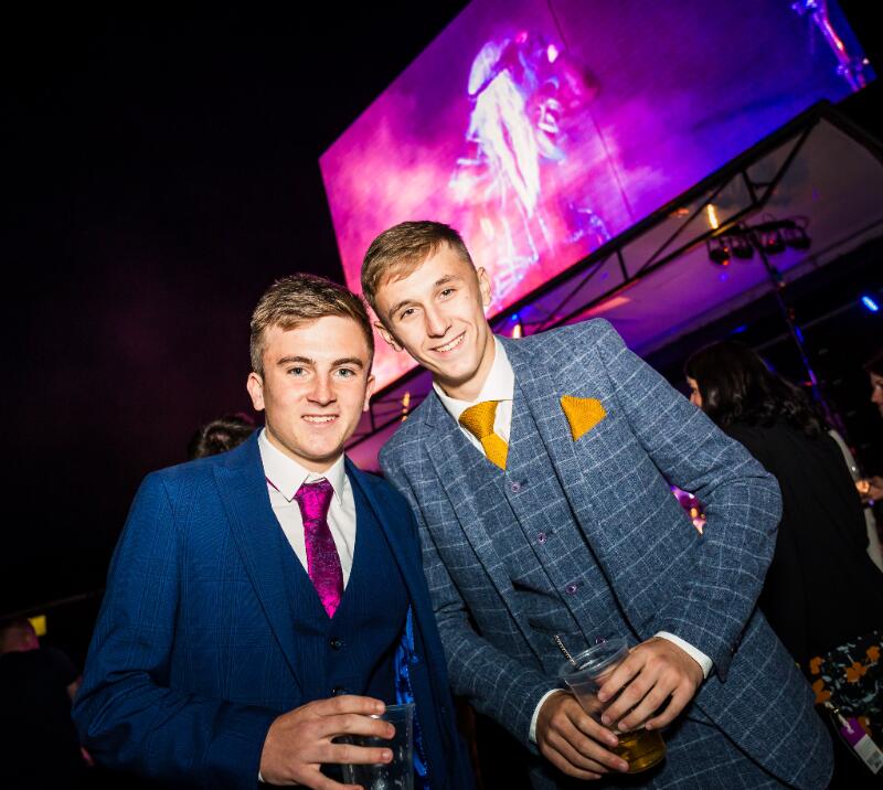 Two race goers in suits enjoying the evening entertainment at Sedgefield