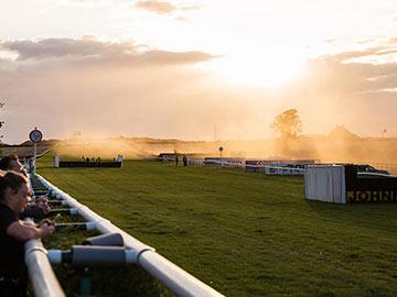 Racing action at dusk at Sedgefield Racecourse.