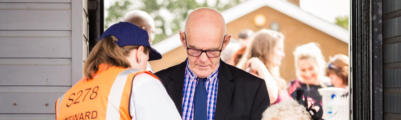 A steward welcomes racegoers to Sedgefield Racecourse