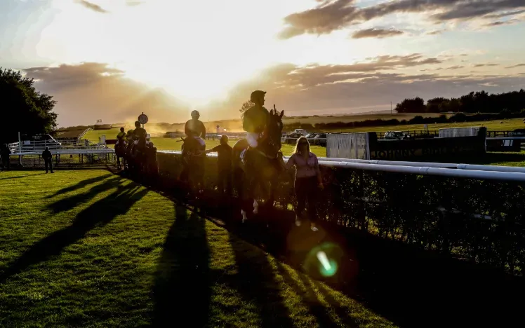 Sunset at Sedgefield Racecourse with horses and jockeys in silhouette 