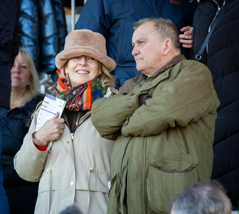 A couple smile in the grandstand at Sedgefield Races whilst holding a race card