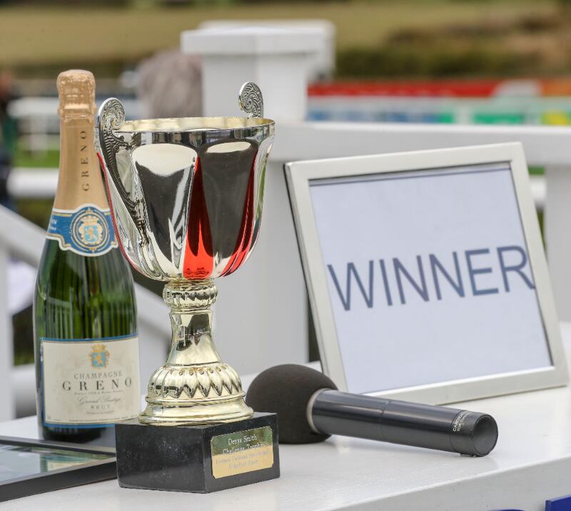 A close up of the Durham National trophy, with a bottle of champagne.