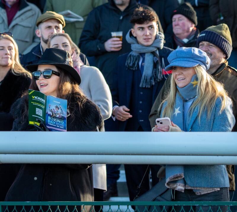 Two ladies in winter hats watch the races at Sedgefield Racecourse